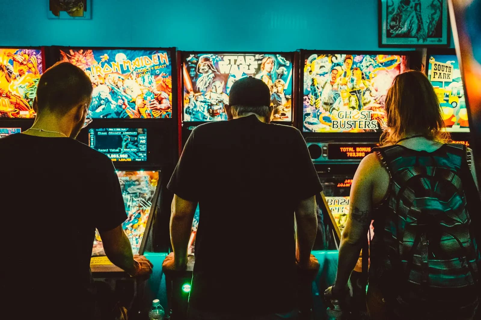 Guests playing arcade games together inside an entertainment venue