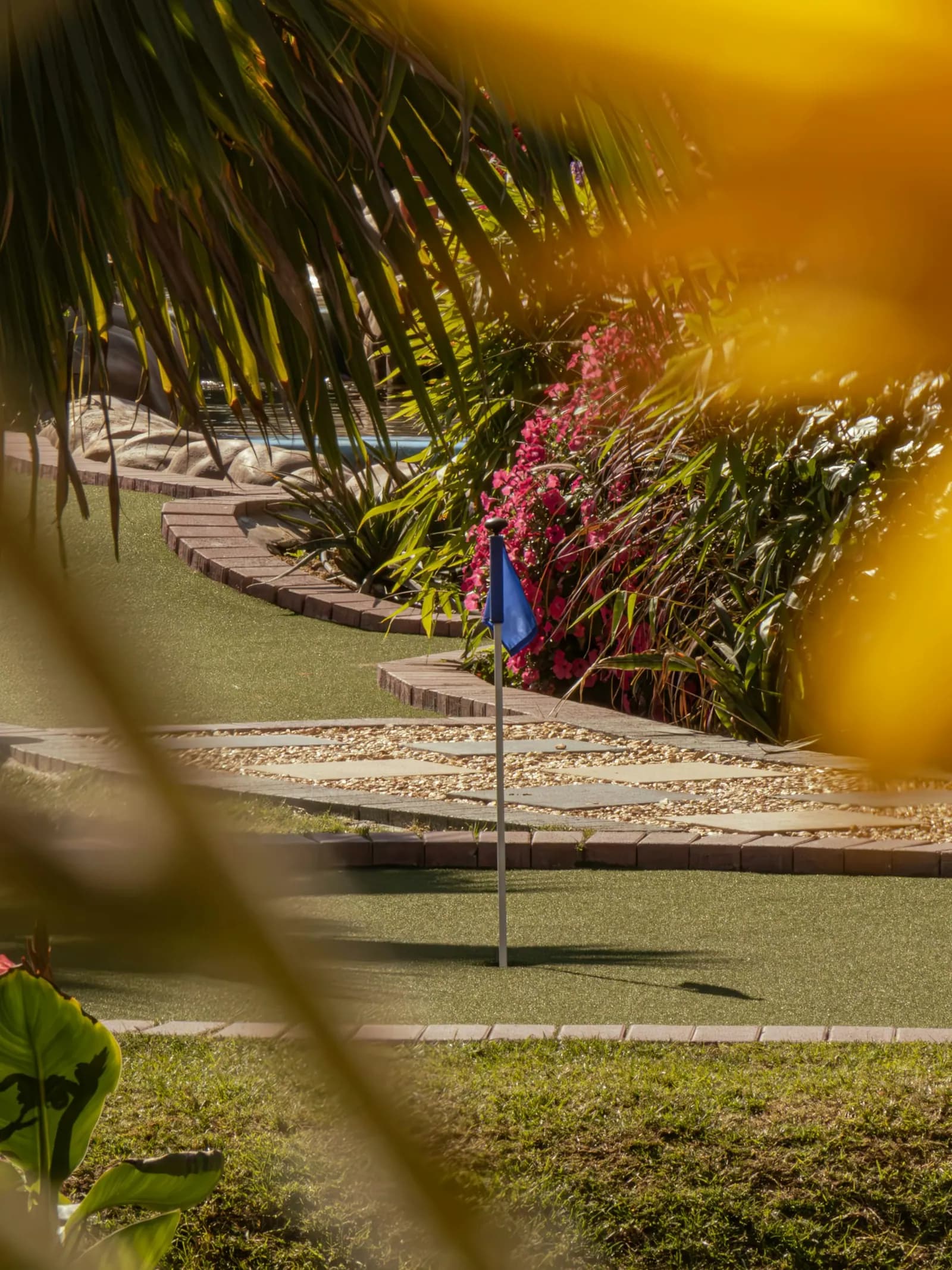 A landscaped miniature golf course seen through tropical foliage